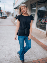 Top features a solid base color, front tie detail, short flutter sleeves, round neck line, elastic waist, and runs true to size! -black