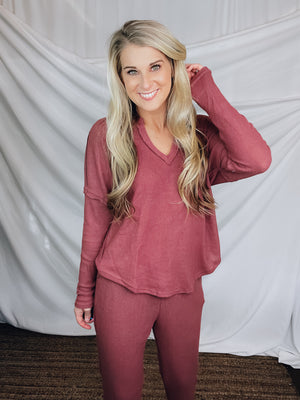 This lounge set features a solid base color, soft material, top with a V-neck line and long sleeves, jogger high waisted pants, surplus pockets with a drawstring and runs true to size!-MARSALA