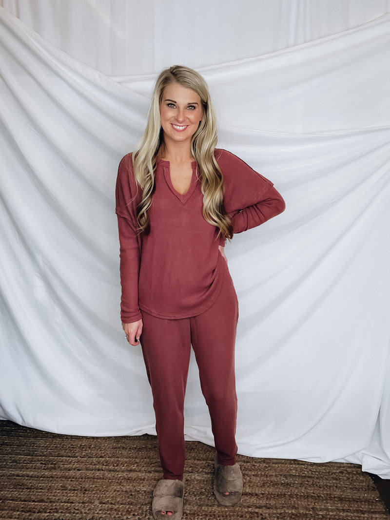 This lounge set features a solid base color, soft material, top with a V-neck line and long sleeves, jogger high waisted pants, surplus pockets with a drawstring and runs true to size!-MARSALA