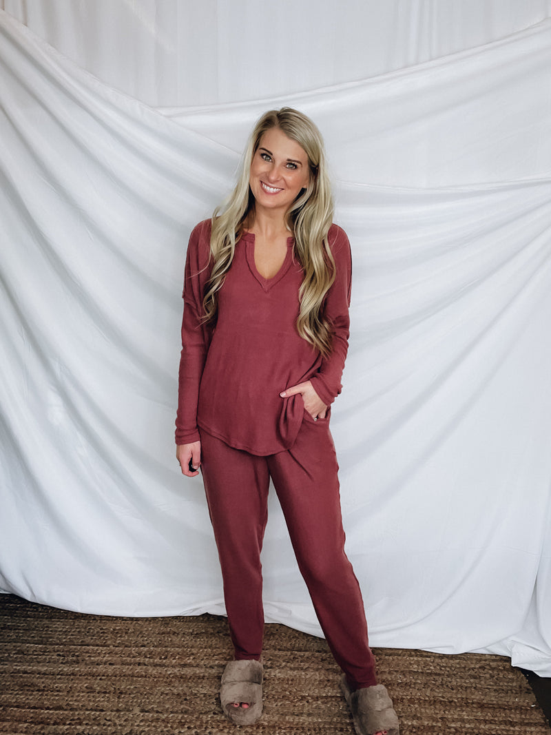 This lounge set features a solid base color, soft material, top with a V-neck line and long sleeves, jogger high waisted pants, surplus pockets with a drawstring and runs true to size!-MARSALA