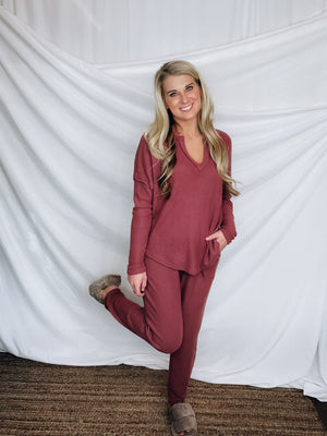 This lounge set features a solid base color, soft material, top with a V-neck line and long sleeves, jogger high waisted pants, surplus pockets with a drawstring and runs true to size!-MARSALA