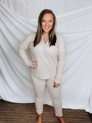 This lounge set features a solid base color, soft material, top with a V-neck line and long sleeves, jogger high waisted pants, surplus pockets with a drawstring and runs true to size!-KHAKI
