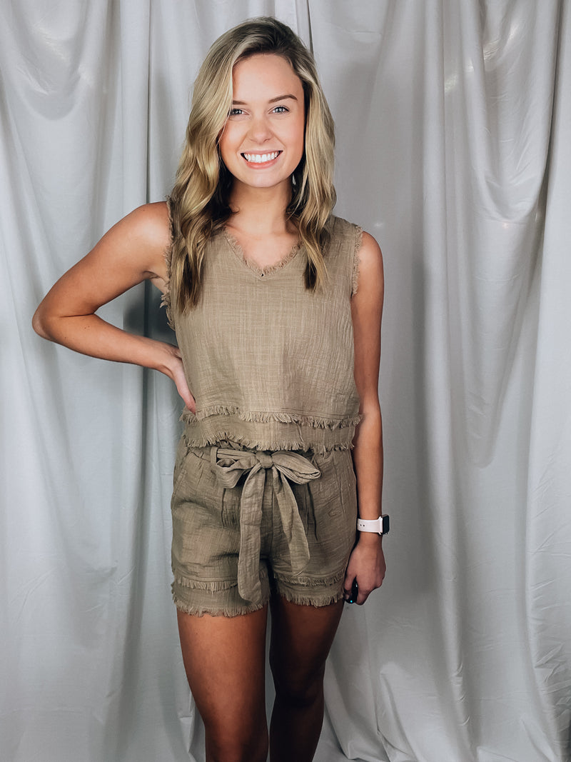 Set offers a solid base color, sleeveless detail, tank and short pieces, frayed lining detail, pockets, tie belt, with a textured look to add the perfect amount of detail. Runs true to size!