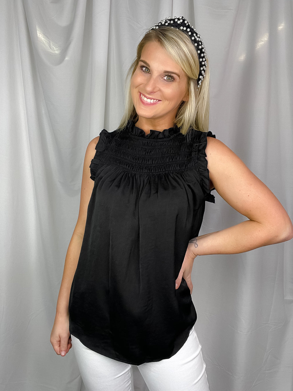 Top features a solid base color, sleeveless detail, smocked detail, ruffle detailing and runs true to size!-black