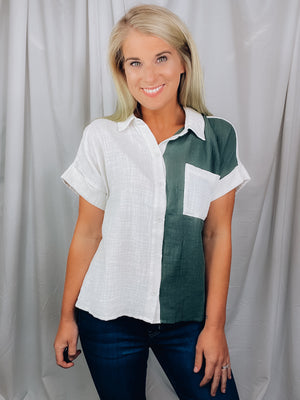 Top features a green/ cream base. short sleeves, V-neck line, collared detail, button down detail and runs true to size! 