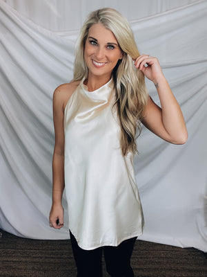 Top features a silky material, halter button closure neck line, sleeveless detail, backless detail, slight cowl neck and runs true to size!-CHAMPAGNE