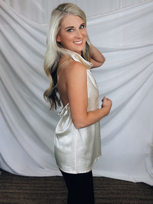 Top features a silky material, halter button closure neck line, sleeveless detail, backless detail, slight cowl neck and runs true to size!-CHAMPAGNE
