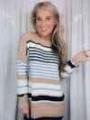 Sweater features a taupe and ivory base, black & blue stripes, long sleeves, round neck line and runs true to size! SUPER SOFT + COZY!