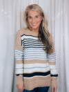 Sweater features a taupe and ivory base, black & blue stripes, long sleeves, round neck line and runs true to size! SUPER SOFT + COZY!