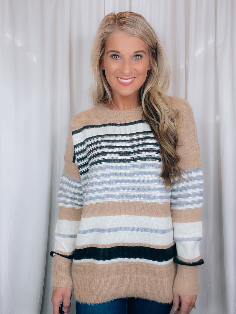 Sweater features a taupe and ivory base, black & blue stripes, long sleeves, round neck line and runs true to size! SUPER SOFT + COZY!