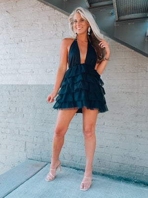 Tulle dress features a base color with a deep V cut-out, adjustable tie detail around the neck, and elastic waistband with an open back. Runs true to size!-black