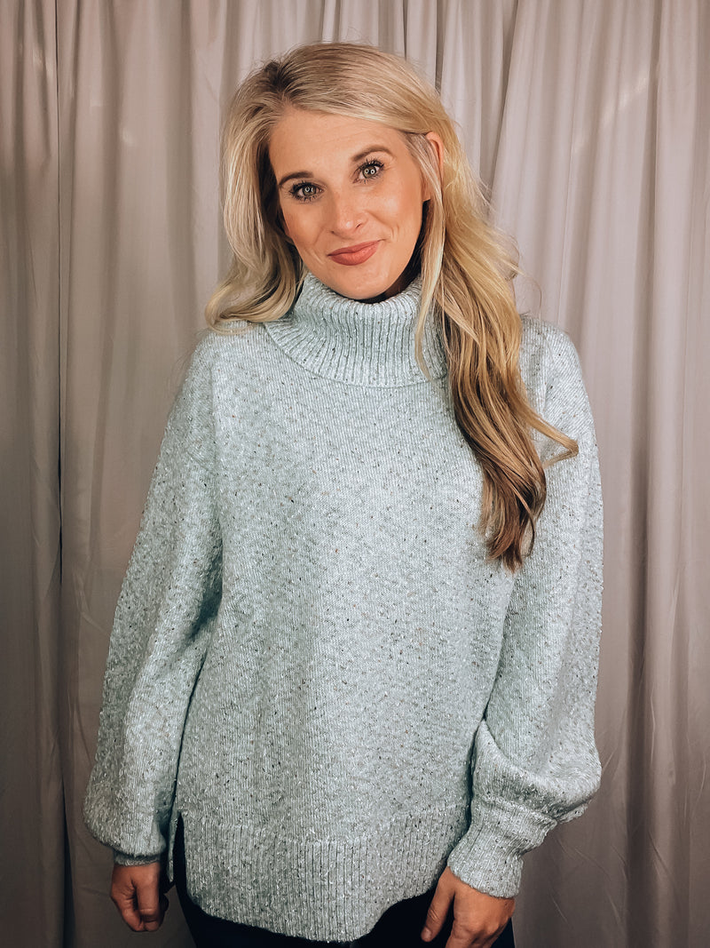 Sweater features a solid base color, heather multi color dot detailing, long sleeves, turtle neck line, side hem slits, and runs true to size!-light blue