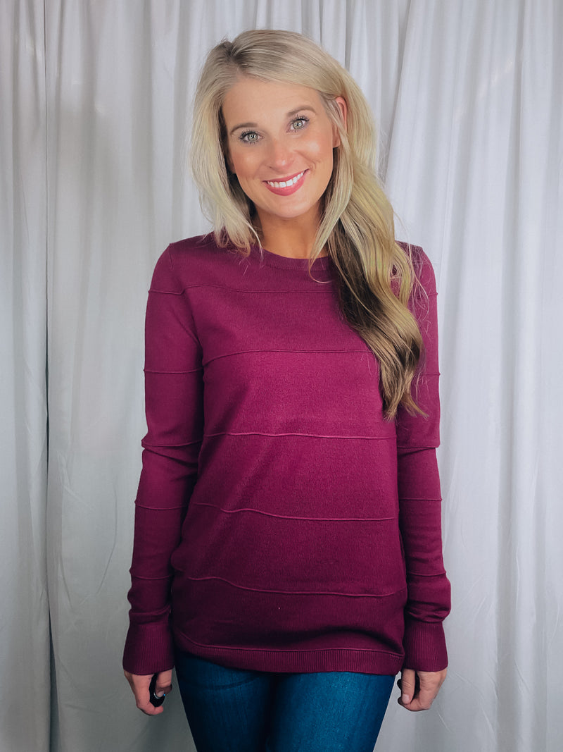 Top features a solid base color, long sleeves, horizontal line detailing, crew neck line and runs true to size!-magenta