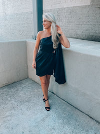 Black satin dress features subtle floral design, side cutout, with a draped, one shoulder detail. Runs true to size!  - Jacquard print - Draped one shoulder - Side ruffle detail - Pleated - Side zipper - 100% Polyester - Lined