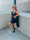 Black satin dress features subtle floral design, side cutout, with a draped, one shoulder detail. Runs true to size!  - Jacquard print - Draped one shoulder - Side ruffle detail - Pleated - Side zipper - 100% Polyester - Lined