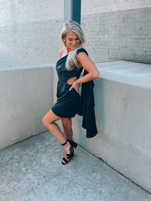 Black satin dress features subtle floral design, side cutout, with a draped, one shoulder detail. Runs true to size!  - Jacquard print - Draped one shoulder - Side ruffle detail - Pleated - Side zipper - 100% Polyester - Lined