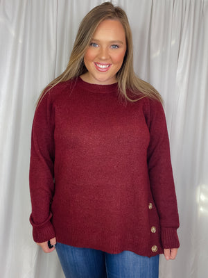 Top features a solid base color, long sleeves, round neck line, soft material, side hem button detail and runs true to size!-burgundy