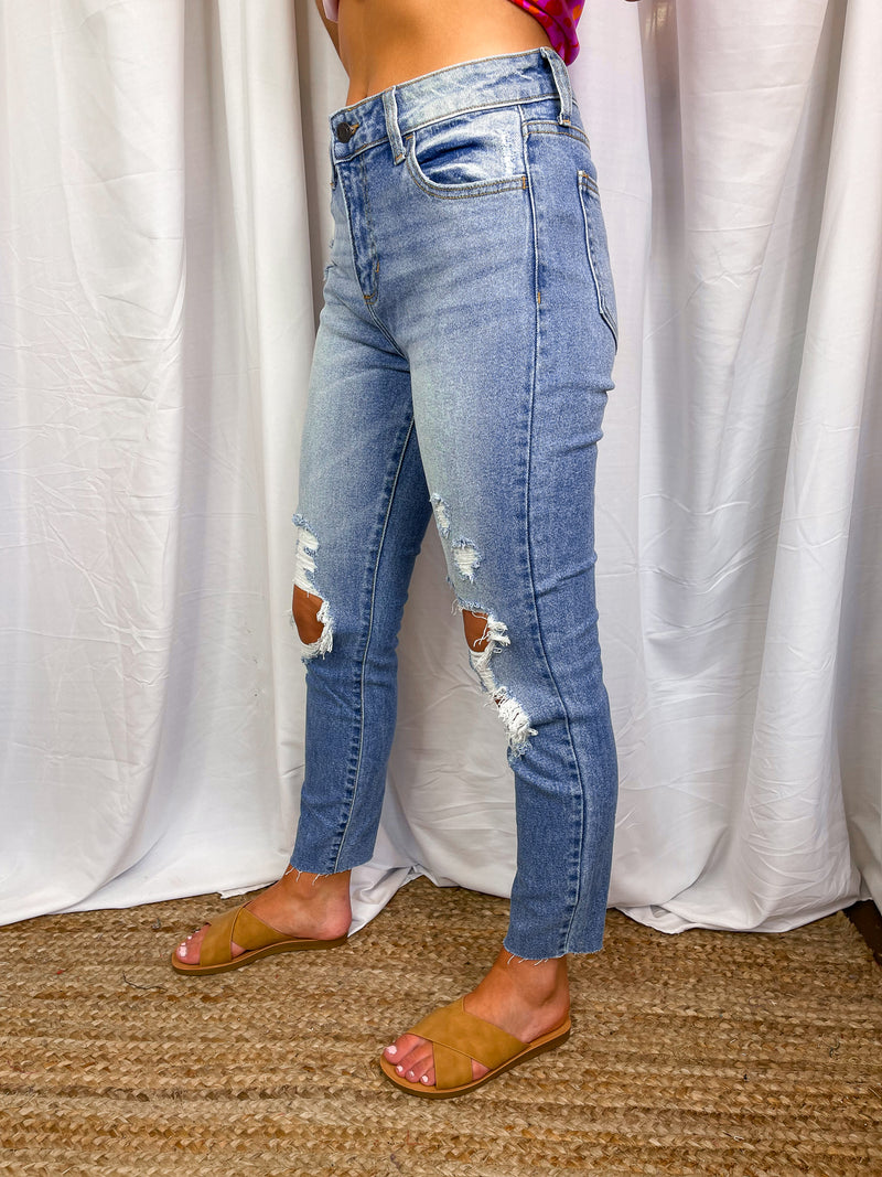 Jeans feature a medium denim wash, high waisted detail, mom skinny fit, front distressing, raw cut hem and runs true to size! 