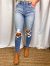 Jeans feature a medium denim wash, high waisted detail, mom skinny fit, front distressing, raw cut hem and runs true to size! 