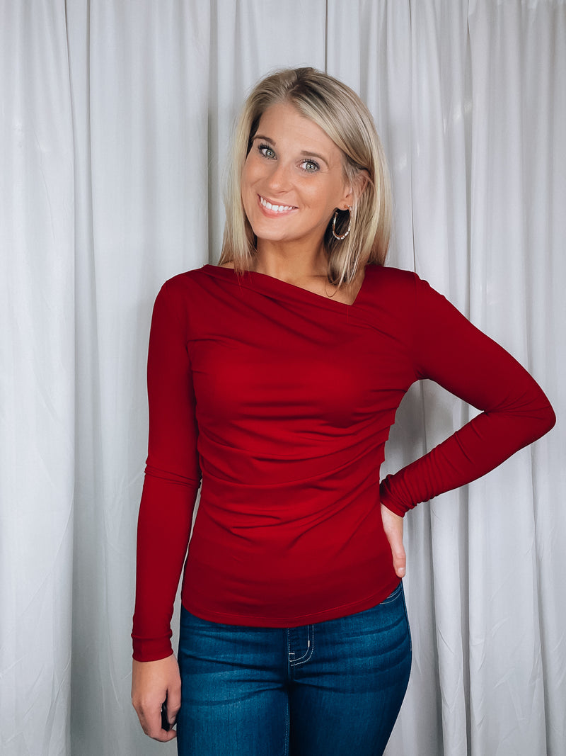 Top features a solid base color, long sleeve, asymmetrical neck line, and runs true to size!-red