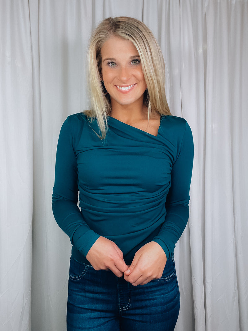 Top features a solid base color, long sleeve, asymmetrical neck line, and runs true to size!-teal