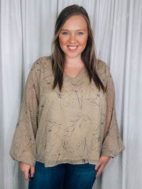 Top features a taupe base, black floral print, underlining, long sleeves, V-neck line, and runs true to size! 