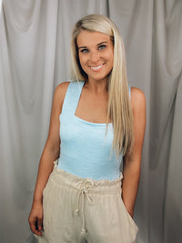 Bodysuit features a heathered light blue color, square neck line, sleeveless detail, cross-open back detail, snap bottom closure, fitted fit and runs true to size! 