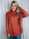 Top features a rust base, long sleeve, turtle neck line, round hem line, soft material and runs true to size! 