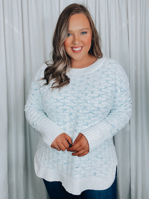 Sweater features a white base, light blue detailing, soft waffle knit material, long sleeves, round neck line and runs true to size! 