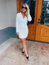 Dress features a white full sequin base, long sleeves, deep V-neck line, back zipper closure, faux double button front detailing, mini length and runs true to size! 