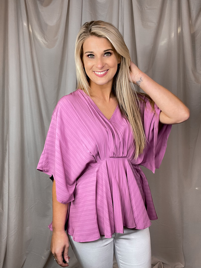 Top features a mauve color, V-neck line, kimono sleeves, fitted waist, lightweight material, flattering fit and runs true to size! 