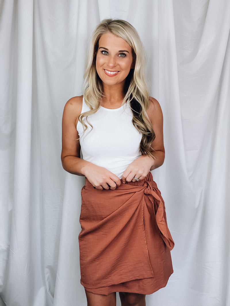 Skirt features solid base color, overlap detail, front tie detail, mini length and runs true to size!-rose