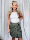 Skirt features solid base color, overlap detail, front tie detail, mini length and runs true to size!-olive