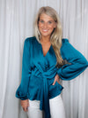 Top features a solid base color, silky material, peplum fit, long sleeves, V-neck line, front draped detail and runs true to size! -teal