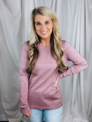 Top features a solid base lavender color, round neck line, long sleeves, pin tucked detail, soft material and runs true to size! 
