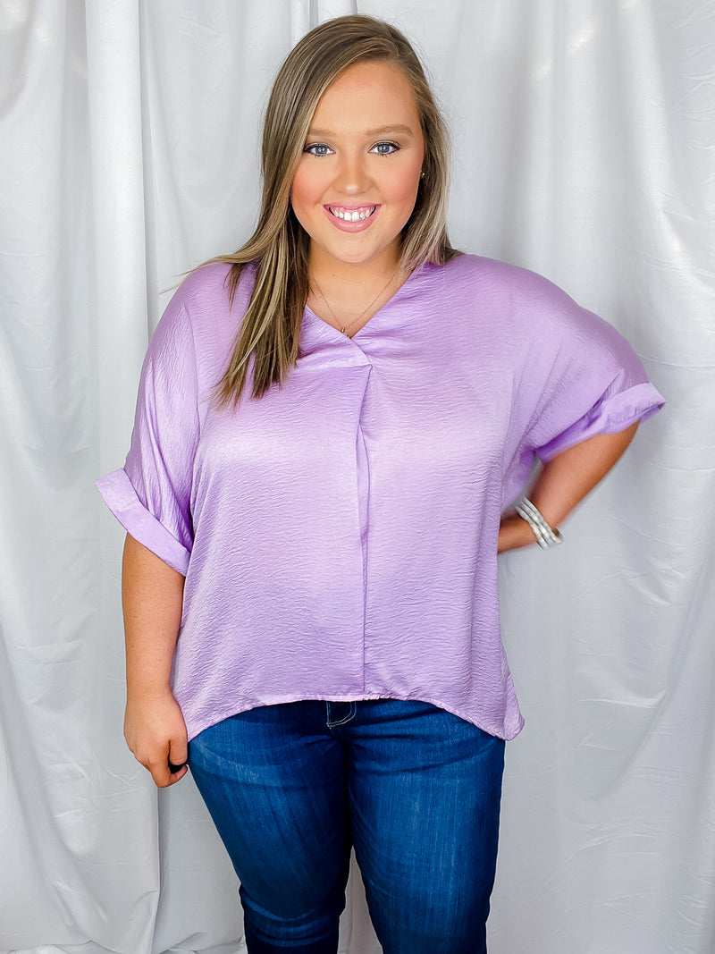 Top features a solid lavender color, V-neck line, high- low hem, cuffed short sleeves, light weight material and runs true to size! 