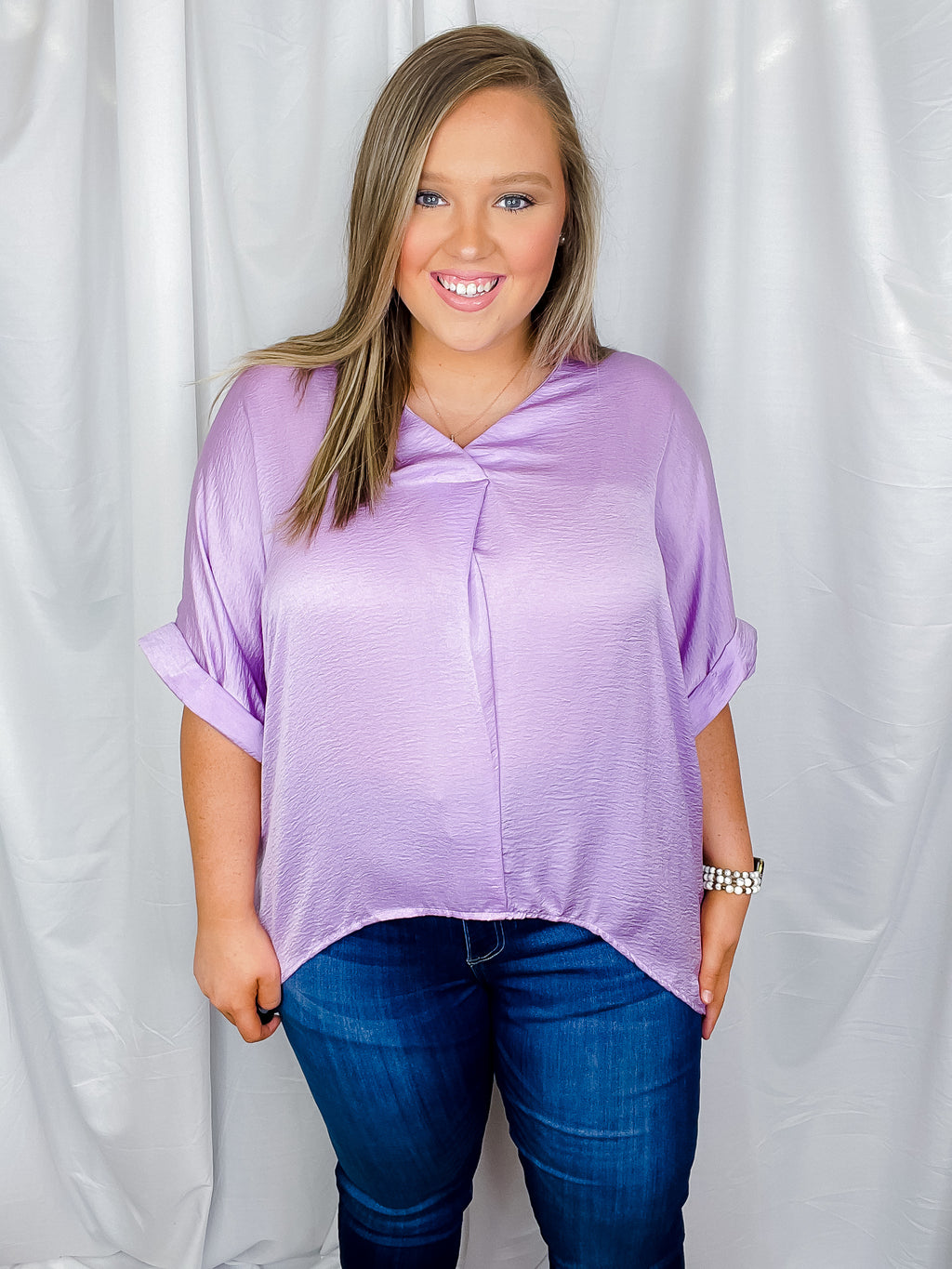 Top features a solid lavender color, V-neck line, high- low hem, cuffed short sleeves, light weight material and runs true to size! 