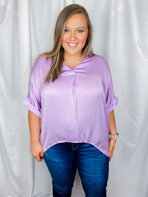 Top features a solid lavender color, V-neck line, high- low hem, cuffed short sleeves, light weight material and runs true to size! 