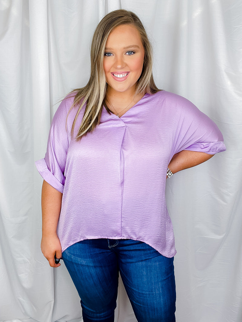 Top features a solid lavender color, V-neck line, high- low hem, cuffed short sleeves, light weight material and runs true to size! 