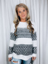 Sweater features an ivory/ black coloring, long sleeves, crew neck line, geo patterned detail, and runs true to size! 