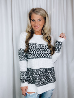 Sweater features an ivory/ black coloring, long sleeves, crew neck line, geo patterned detail, and runs true to size! 