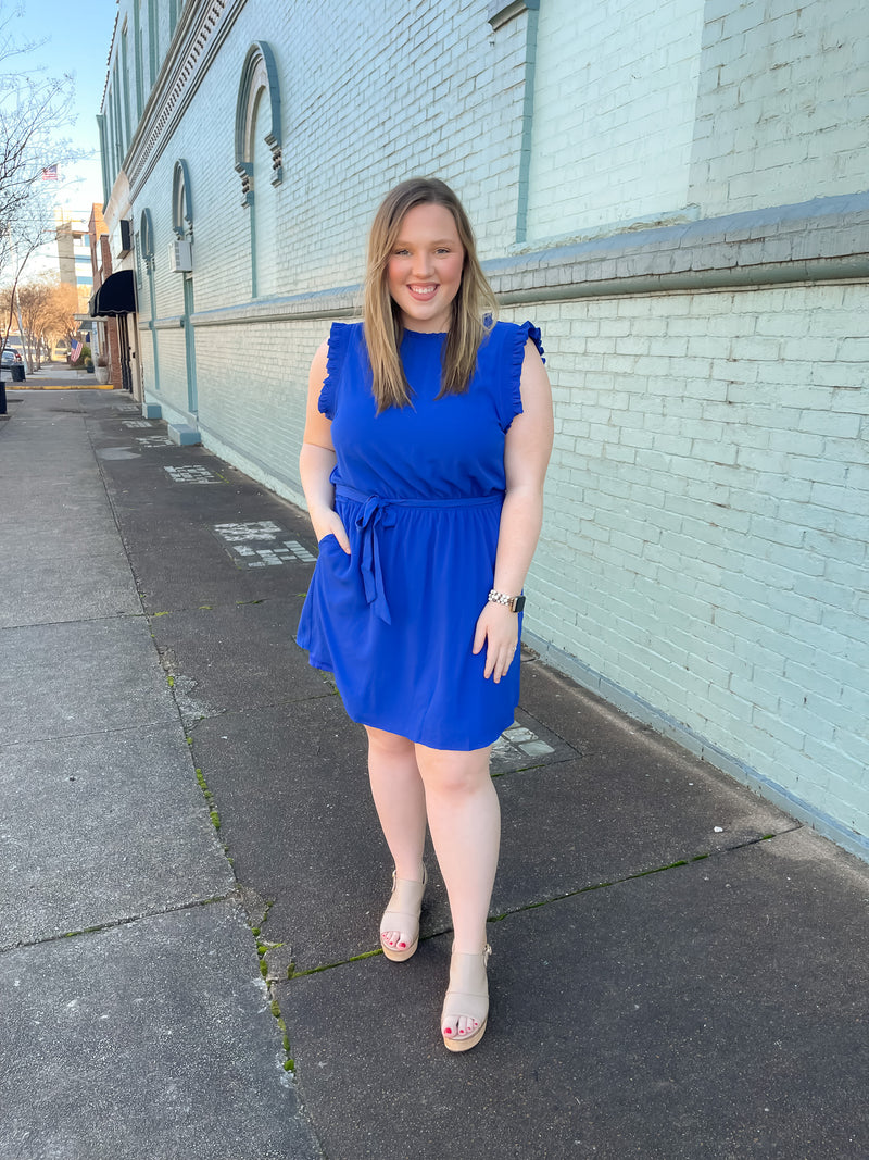 Dress features a stunning royal blue color, ruffle hem line detail, elastic waist, tie belt addition, functional pockets and runs true to size! 