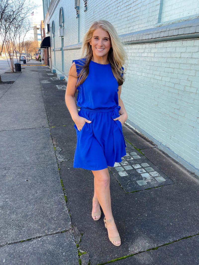 Dress features a stunning royal blue color, ruffle hem line detail, elastic waist, tie belt addition, functional pockets and runs true to size! 