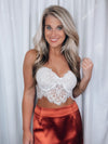 Top features a white coloring, lace detail, corset fit, cropped length, adjustable straps and runs true to size! 