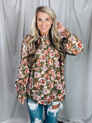 Top features a solid base color, floral print, long sleeves, ruffle neck line, fitted elastic wrist detail, and runs true to size! -green