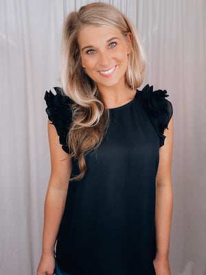 Top features a jet black color, ride ruffle hem, round neck line, key hole button closure, short sleeves, and runs true to size!   *material is a tad sheer* 