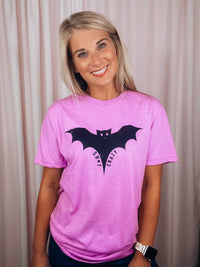 Graphic features a solid base colored tee, short sleeves, unisex fit, distressed black design and runs true to size!-pink