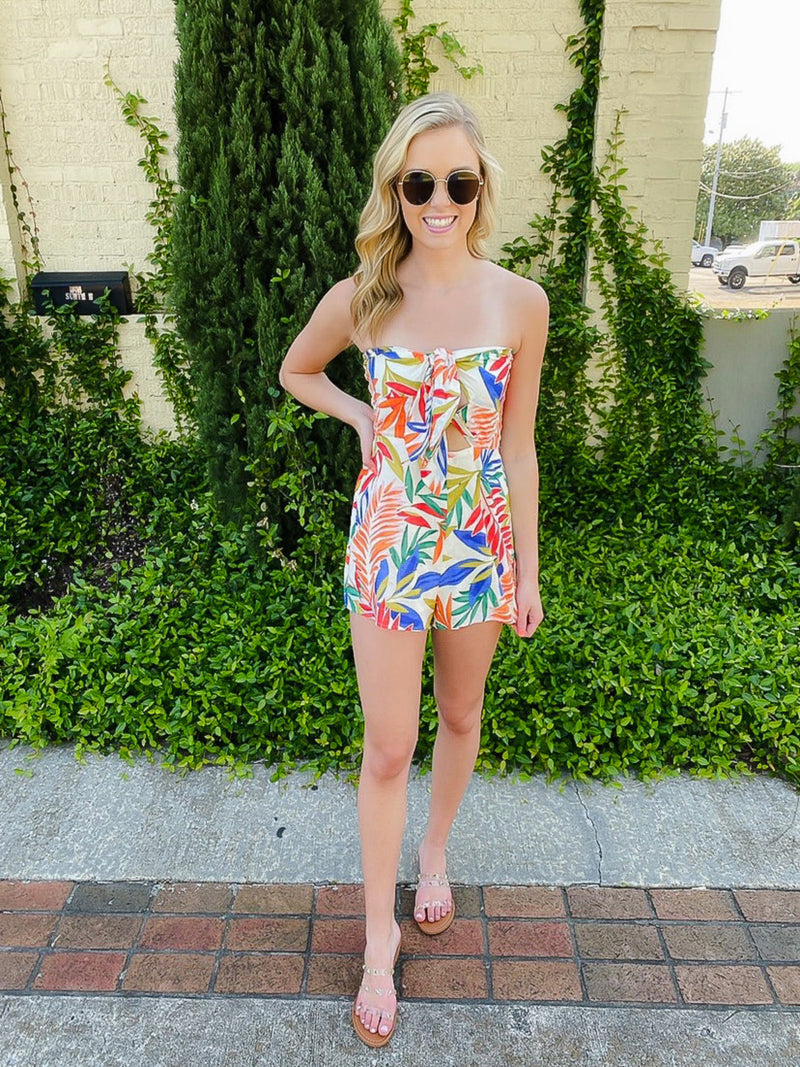 Romper features a red/royal floral print, tube top, front tie detail, and runs true to size! 