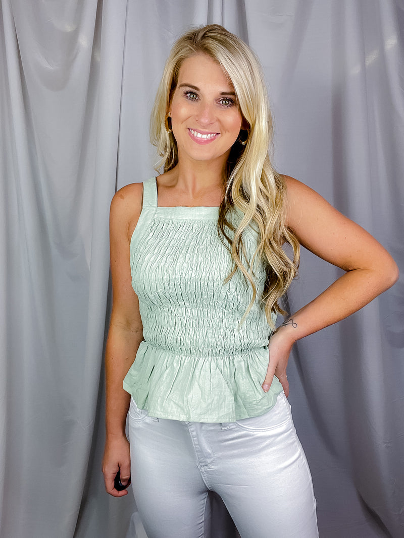 Top features a solid base color, sleeveless detail, halter neck line, adjustable straps, cross back tie, cropped length, smocked chest and runs true to size! 