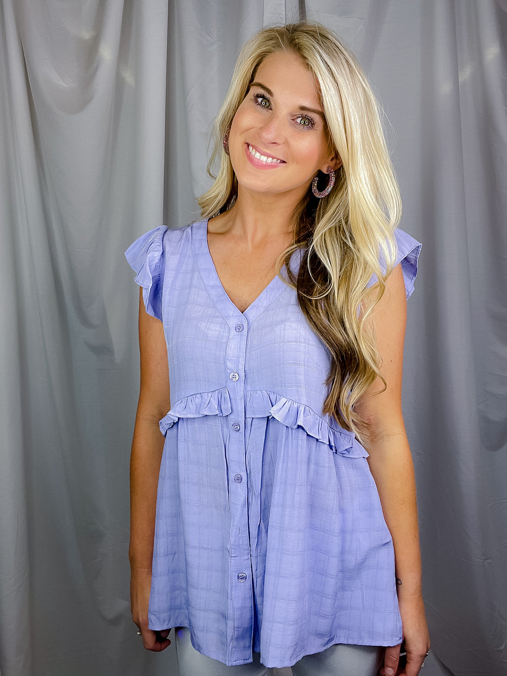 Top features a lilac color, textured detail, functional button down detail, V-neck line, short sleeves and runs true to size! 
